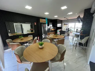 Sala de jantar com mesa de madeira e cadeiras no interior da propriedade.