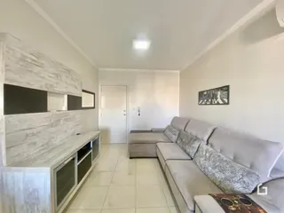 Sala de estar com sofá e revestimento de parede claro.