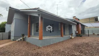 Fachada de uma casa em Lajeado, Brasil com paredes cinzas e detalhes em tijolo aparente.