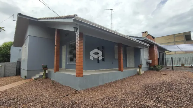 Fachada de uma casa em Lajeado, Brasil com paredes cinzas e detalhes em tijolo aparente.