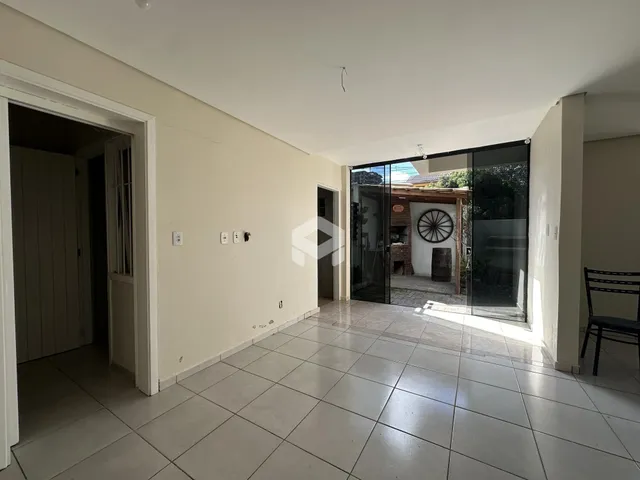 Interior de uma área com piso de cerâmica e portas de vidro que dão acesso ao exterior.