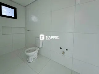 Foto de um banheiro com piso de cerâmica e vaso sanitário branco.