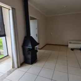 Foto de um corredor interno com piso de cerâmica e um duto vertical.