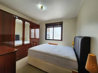 Quarto com cama e armário de madeira.