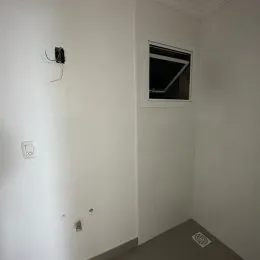 Foto de um corredor interno com paredes brancas.
