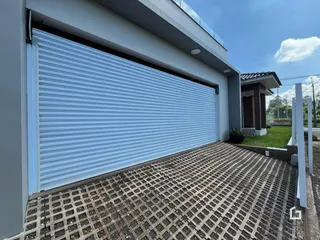 Fachada da casa com garagem e piso de tijolos na Lajeado.