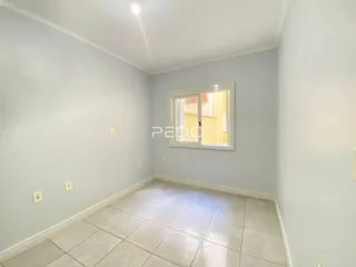 Quarto interno com piso de cerâmica claro e paredes em tom de cinza claro.