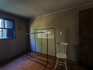 Ambiente interno de uma sala com piso de cerâmica e uma estrutura metálica no centro.