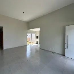 Hall de entrada com piso de concreto polido e paredes claras.