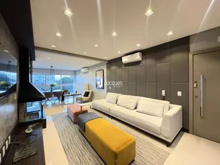 Sala de estar moderna com sofá e ambiente iluminado.