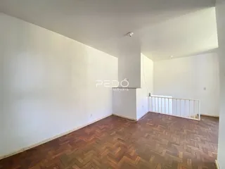 Ambiente interno de uma sala com piso de madeira no imóvel.