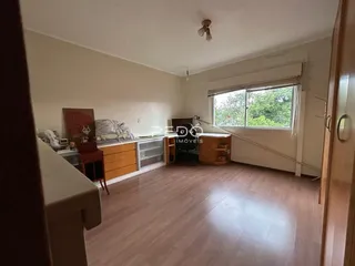 Ambiente interno de uma sala de estar com piso de madeira clara.
