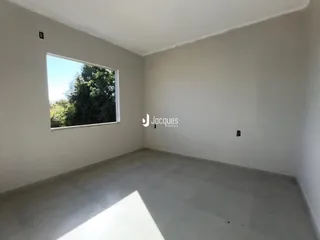 Uma sala com grande janela de vista para a natureza.