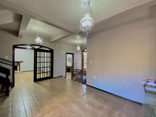 Foto de um corredor com piso de madeira e lustre no teto.