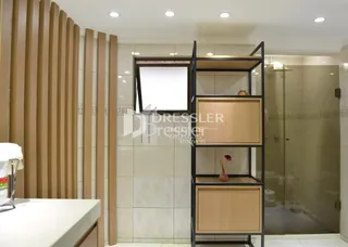 Interior de um corredor com painéis de madeira e divisória de vidro.