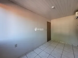 Vista interna de um ambiente com piso de cerâmica e porta de madeira.