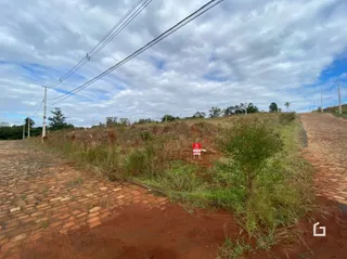 Vista externa de uma área de terra com vegetação ao longo de um caminho de tijolos.
