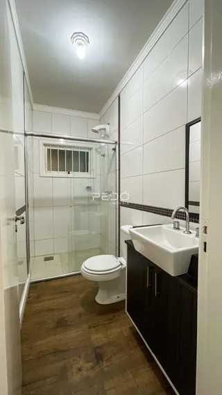 Foto de um banheiro moderno com revestimento branco e piso de madeira.