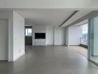Sala ampla com piso de porcelanato cinza e vista da cidade através da porta de vidro.