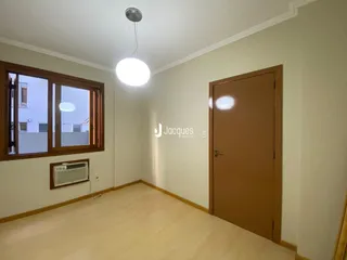 Sala de estar com piso de madeira clara e janela.
