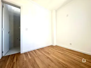 Ambiente interno com piso de madeira clara e paredes brancas.
