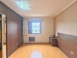 Sala de estar com piso de madeira clara e paredes neutras.