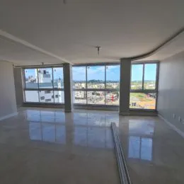 Sala ampla com grandes janelas que oferecem vista da cidade.