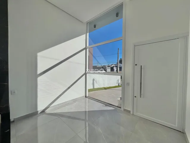 Interior de uma sala com grande porta de vidro voltada para o exterior.