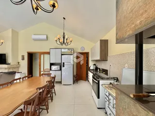 Imagem de uma cozinha e sala de jantar em uma residência.