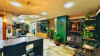 Sala de estar com decoração verde e móveis de madeira.