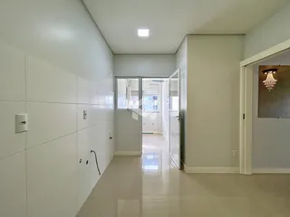 Corredor interno de uma residência com paredes brancas.