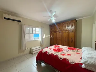 Quarto com cabeceira e armário de madeira em um imóvel no Brasil.