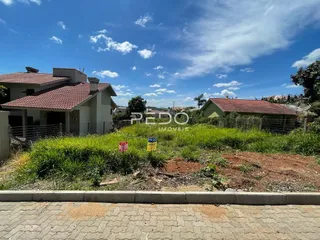 Fachada de uma residência em Lajeado, Brasil, com vegetação no primeiro plano.