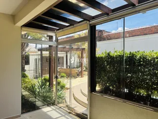 Vista de uma área interna com portas de vidro que se abre para um jardim externo.