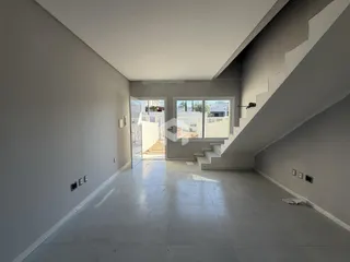 Vista de um corredor interno com piso de cerâmica e escadaria.