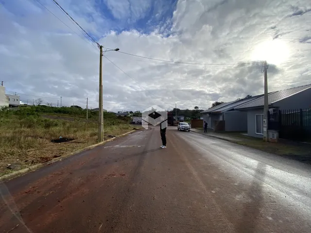 Vista da rua em Lajeado, Brasil, com postes de luz e uma residência ao fundo.