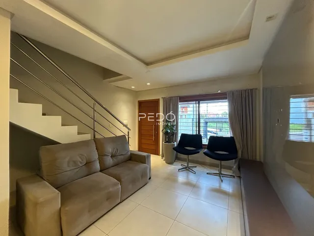 Sala de estar com sofá e escadaria em um apartamento no Brasil.