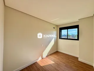 Uma foto de um cômodo interno com piso de madeira e uma janela com vista para a paisagem.