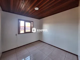 Vista interna de um cômodo com piso de cerâmica e teto de madeira.