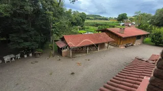 Fachada de uma construção rústica com telhado de telhas vermelhas em uma área rural de Lajeado.