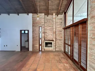 Sala de estar com paredes de tijolo aparente e teto de madeira.