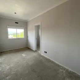 Foto de um ambiente interno com paredes brancas e piso de concreto.