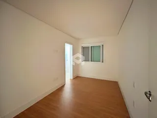 Vista interna de um cômodo com piso de madeira e parede clara.