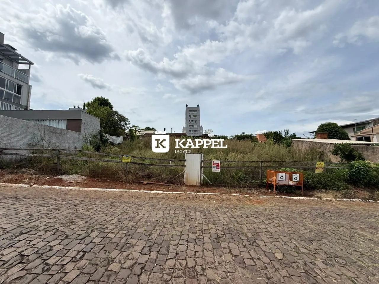 Vista externa da propriedade mostrando uma cerca e área pavimentada.