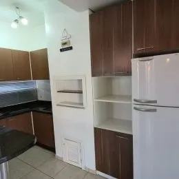 Foto de uma cozinha com armários de madeira e bancada.
