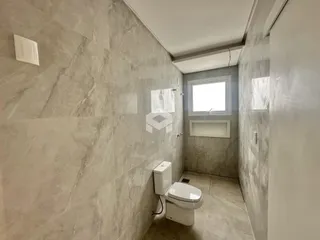 Corredor interno com revestimento de parede em tons de cinza claro.