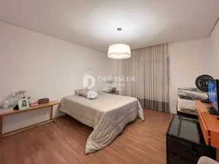 Quarto com piso de madeira e cama.