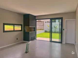 Sala de estar com porta de vidro abrindo para o jardim externo.
