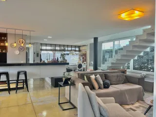 Sala de estar ampla com decoração moderna e acesso a uma escadaria.