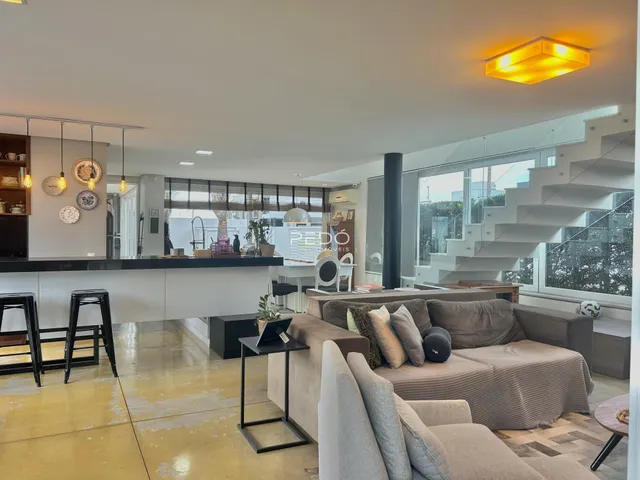 Sala de estar ampla com decoração moderna e acesso a uma escadaria.